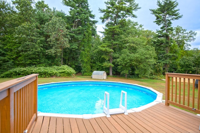 outdoor pool featuring an outbuilding, a yard, a deck, and a shed