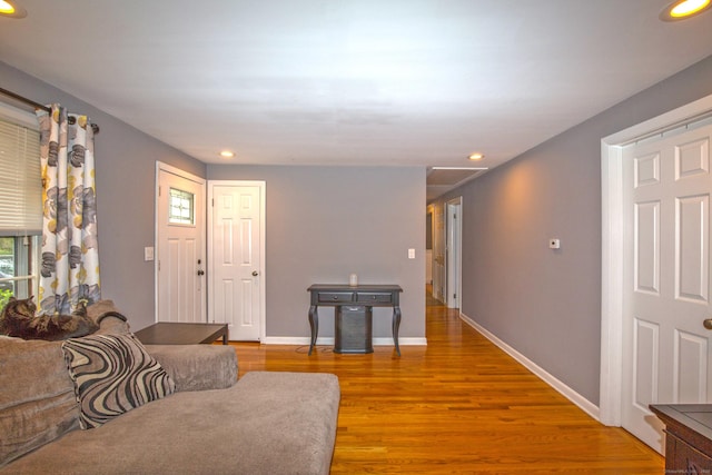 living area with baseboards, wood finished floors, and recessed lighting