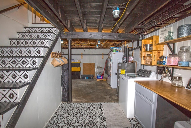 unfinished basement featuring washer / dryer, water heater, and stairs