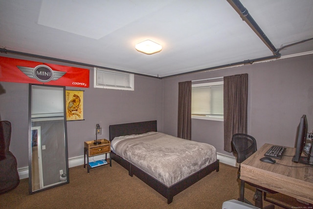 bedroom with a baseboard radiator, dark carpet, baseboard heating, and baseboards