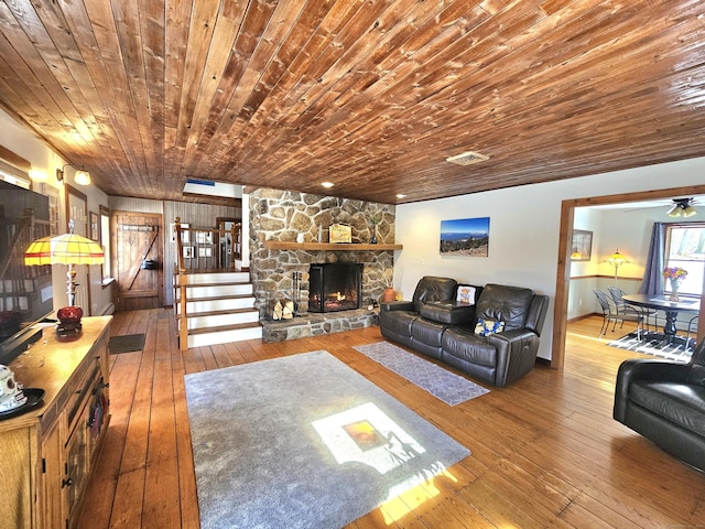 living area with hardwood / wood-style floors, stairway, a fireplace, and visible vents