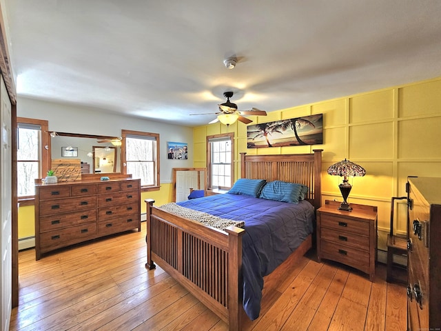 bedroom with light wood-style floors, a baseboard heating unit, and baseboard heating