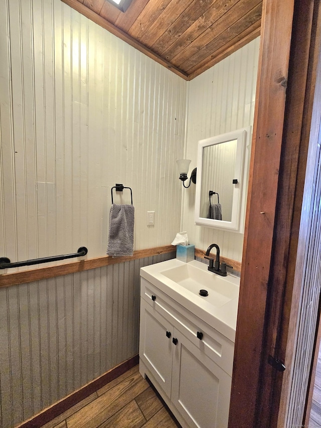 bathroom with wooden ceiling, vanity, and wood finished floors