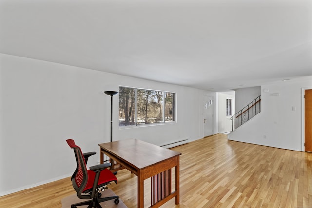 office area featuring a baseboard heating unit and light wood finished floors