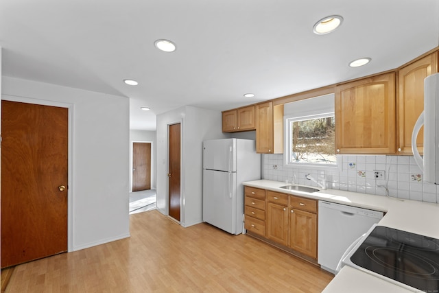 kitchen with light countertops, white appliances, light wood-type flooring, and decorative backsplash