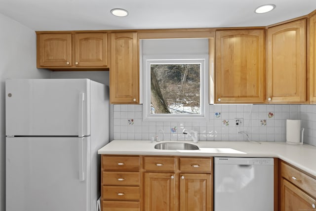 kitchen with white appliances, light countertops, a sink, and decorative backsplash