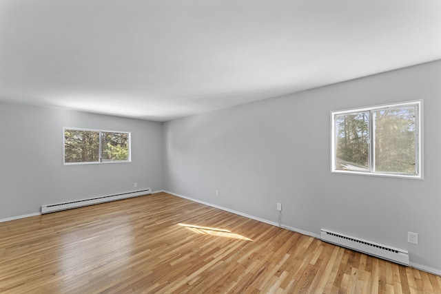 spare room with light wood-style floors, baseboards, and baseboard heating