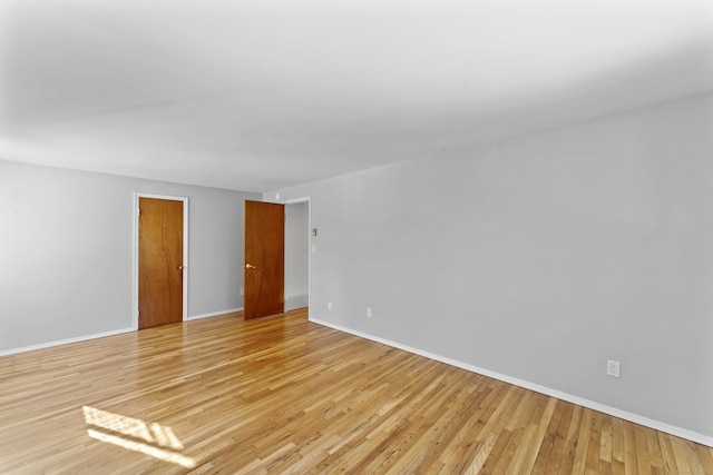 unfurnished room featuring light wood-type flooring and baseboards