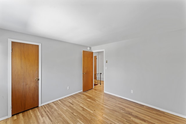 spare room featuring light wood finished floors and baseboards