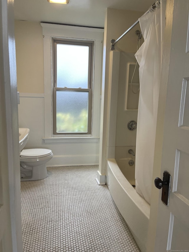 full bath featuring baseboards, shower / bathtub combination with curtain, toilet, and tile patterned floors