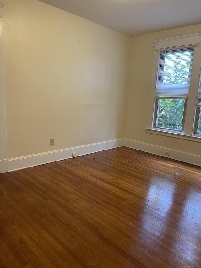 empty room featuring dark wood-style floors and baseboards