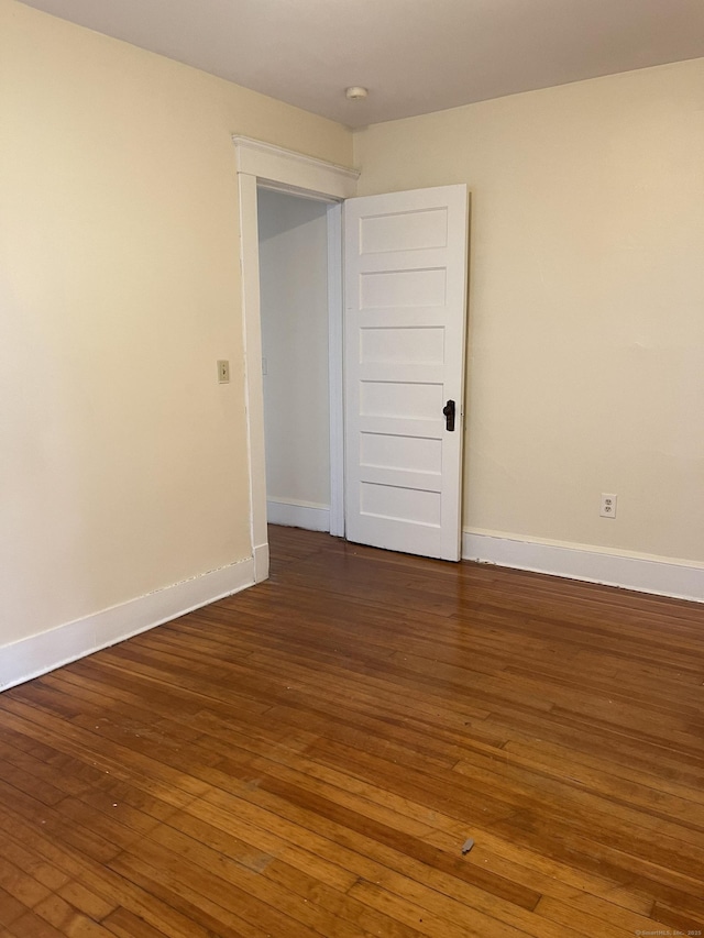 unfurnished room with dark wood-style floors and baseboards