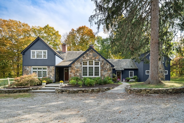 view of front of house featuring stone siding and a chimney