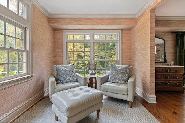 living area with wood finished floors, a wealth of natural light, and crown molding