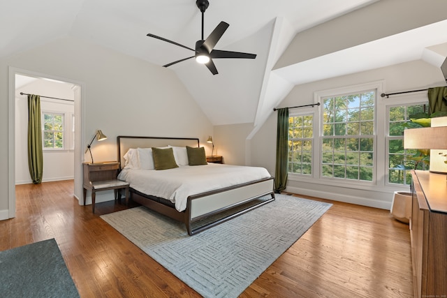 bedroom with a ceiling fan, lofted ceiling, baseboards, and wood finished floors