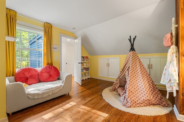 recreation room with lofted ceiling, baseboards, and wood finished floors