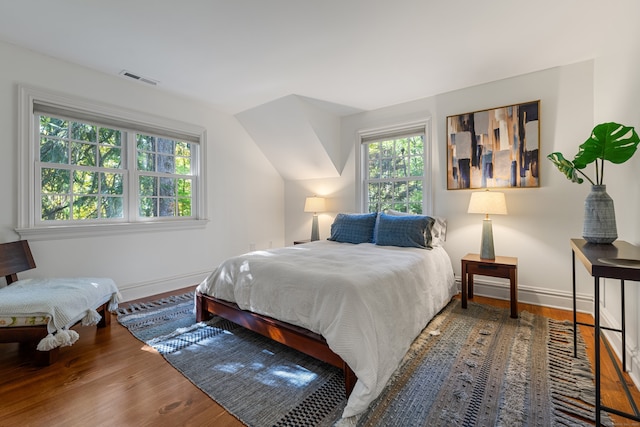 bedroom featuring wood finished floors, visible vents, and baseboards