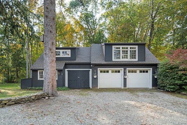 view of front of home with driveway and a shingled roof