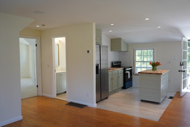 kitchen featuring light wood-type flooring, visible vents, butcher block countertops, range with electric cooktop, and stainless steel fridge with ice dispenser