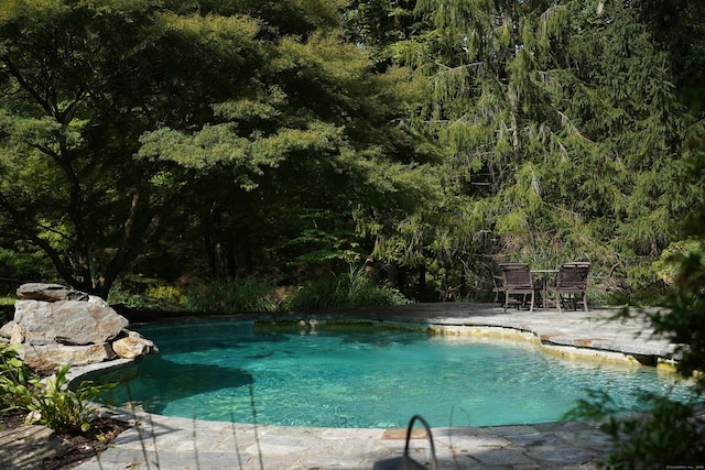 outdoor pool with outdoor dining area and a patio area