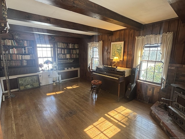 interior space with hardwood / wood-style floors, beamed ceiling, built in features, and wooden walls