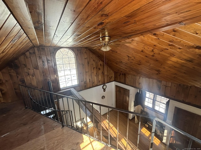 additional living space featuring lofted ceiling, wood walls, wooden ceiling, and a healthy amount of sunlight