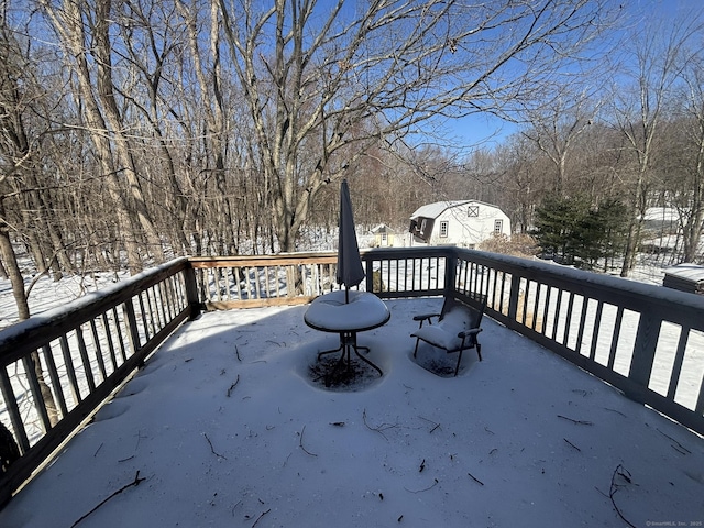 snow covered deck with an outbuilding