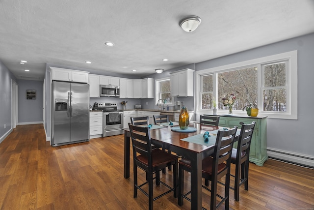 dining area with dark wood-style floors, recessed lighting, baseboard heating, a textured ceiling, and baseboards