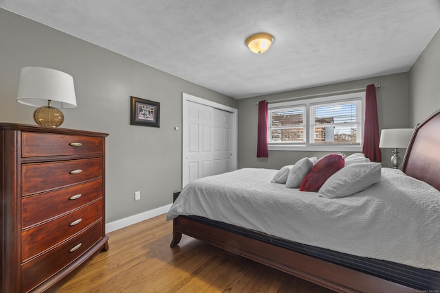 bedroom featuring baseboards, a closet, and light wood-style floors