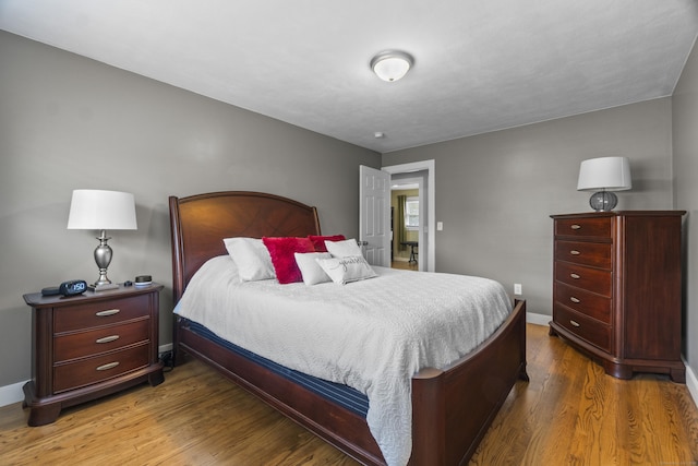 bedroom featuring baseboards and wood finished floors