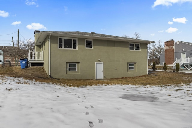 snow covered property with stucco siding