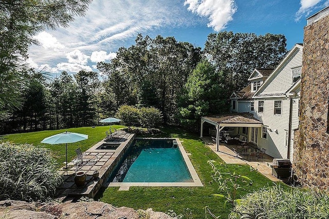 pool with a patio and a yard