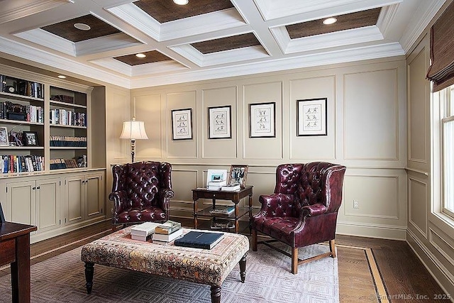 sitting room featuring coffered ceiling, a decorative wall, beamed ceiling, and wood finished floors