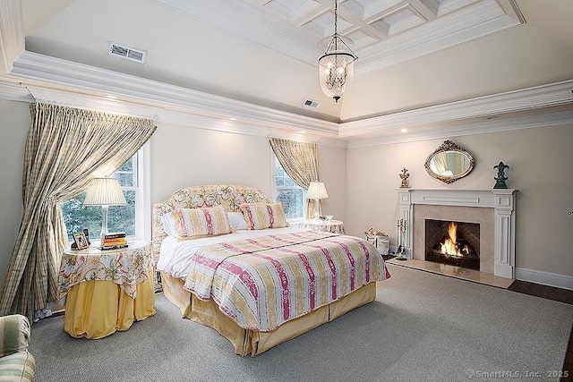 carpeted bedroom featuring ornamental molding, coffered ceiling, a high end fireplace, and visible vents