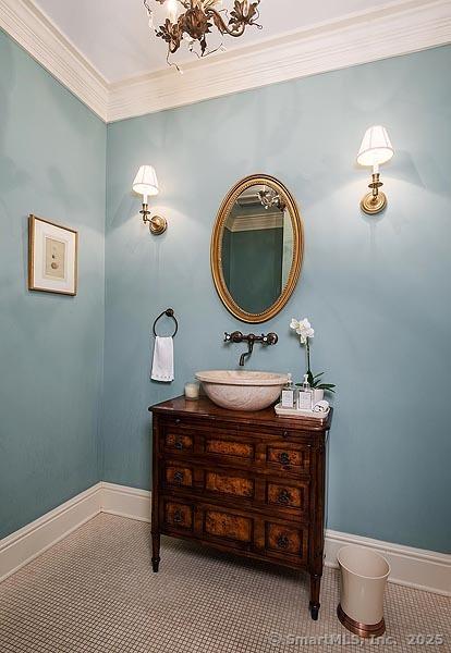 bathroom featuring ornamental molding, vanity, and baseboards