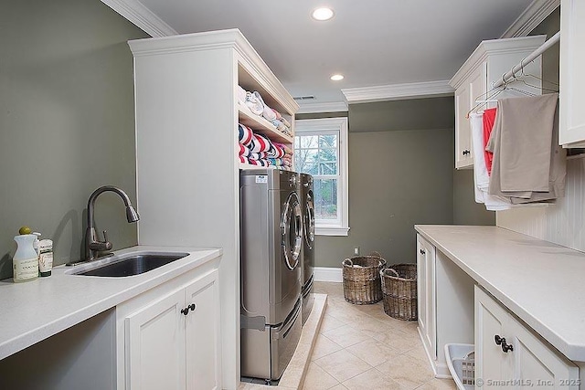 laundry room with light tile patterned flooring, washing machine and dryer, a sink, cabinet space, and crown molding