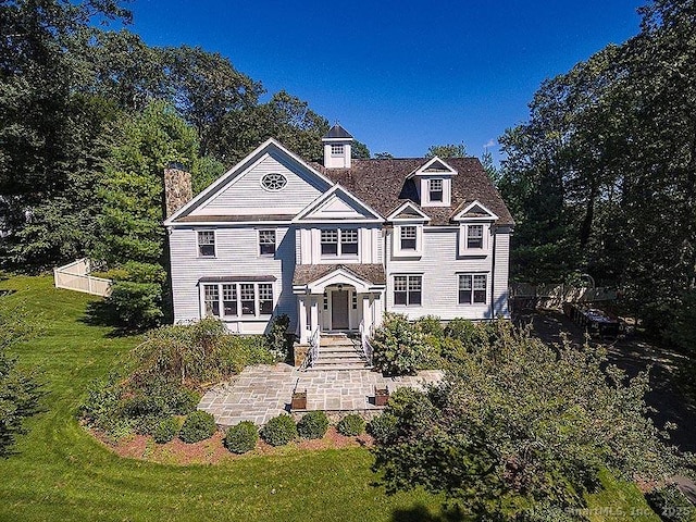 view of front of house featuring a front lawn and a chimney