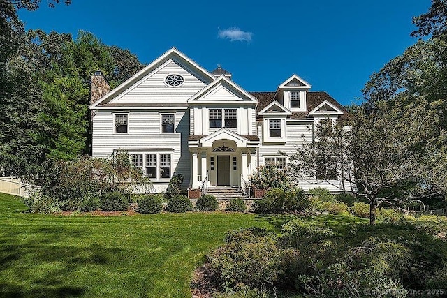 view of front of house featuring a front lawn and a chimney