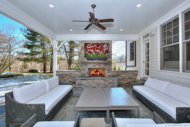 view of patio / terrace with ceiling fan and an outdoor living space with a fireplace