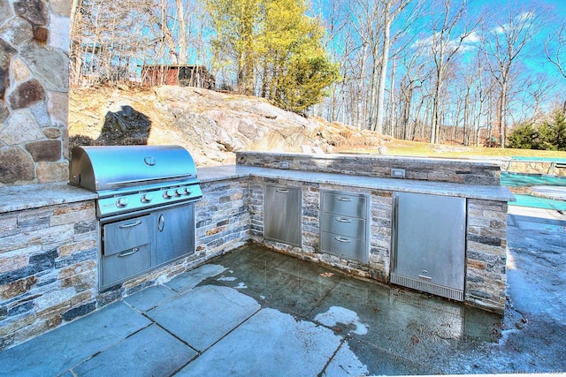 view of patio / terrace with exterior kitchen and a grill