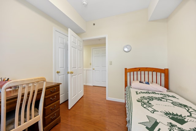 bedroom featuring light wood finished floors and baseboards