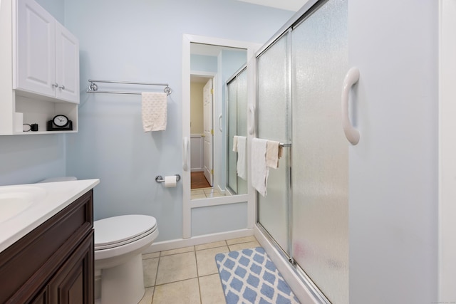 bathroom featuring a stall shower, baseboards, toilet, tile patterned floors, and vanity