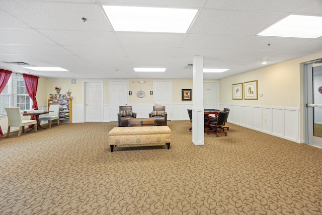 living room featuring wainscoting, carpet flooring, visible vents, and a drop ceiling