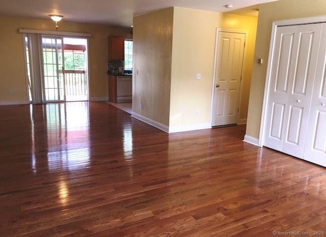 unfurnished room featuring baseboards and dark wood finished floors