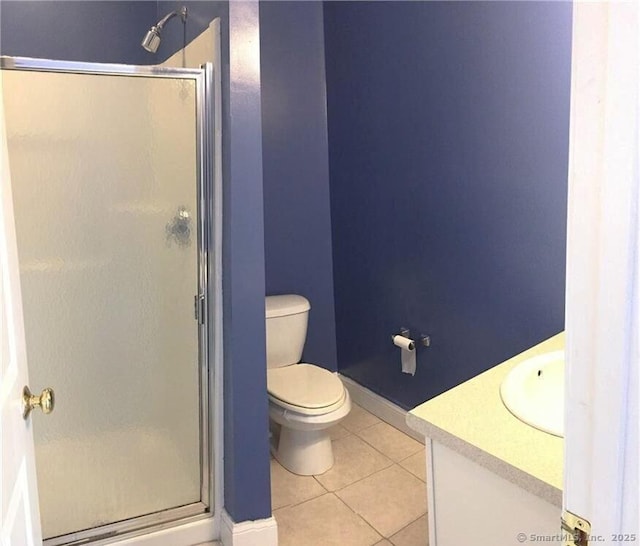 bathroom with toilet, a shower stall, vanity, and tile patterned floors