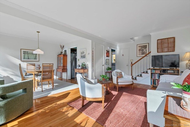 living room featuring ornamental molding, stairway, and wood finished floors