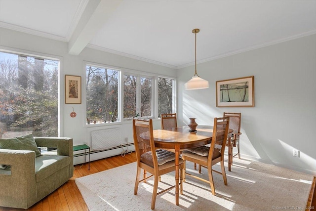 dining area featuring crown molding, beam ceiling, a baseboard heating unit, and wood finished floors