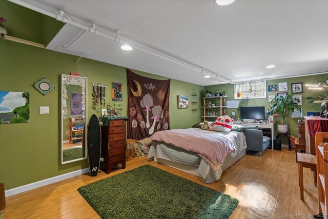 bedroom featuring light wood-style floors and baseboards