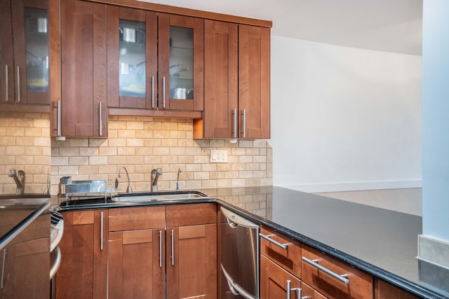 kitchen with brown cabinets, backsplash, stainless steel dishwasher, glass insert cabinets, and a sink