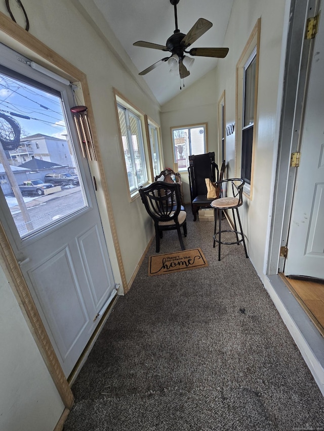 foyer entrance with lofted ceiling, carpet, baseboards, and a ceiling fan